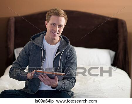 Man using tablet computer on bed View Large Photo Image Stock Photography - Man using tablet computer on bed. Fotosearch