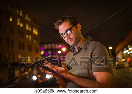 Man using tablet computer on city street View Large Photo Image Stock Image - Man using tablet computer on city street. Fotosearch