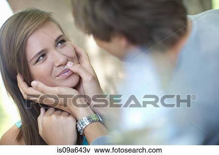 Stock Photo - Man wiping coffee foam off girlfriend. Fotosearch