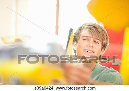 Picture - Man working on model airplane. Fotosearch