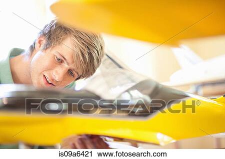 Man working on model airplane View Large Photo Image Stock Image - Man working on model airplane. Fotosearch