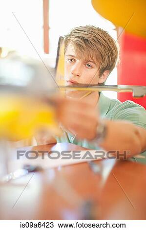 Stock Image - Man working on model airplane. Fotosearch
