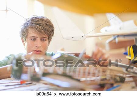 Stock Photo - Man working on model airplane. Fotosearch
