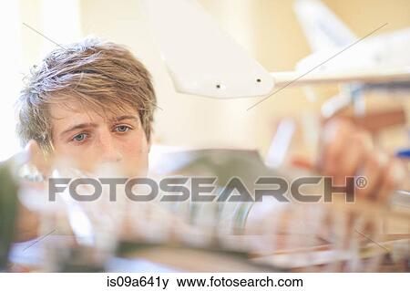 Stock Photo - Man working on model airplane. Fotosearch