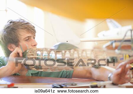 Man working on model airplane View Large Photo Image Stock Photo - Man working on model airplane. Fotosearch