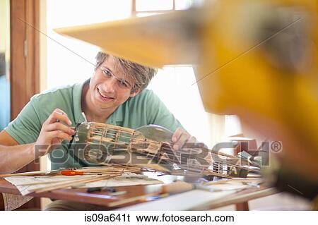 Stock Photograph - Man working on model airplane. Fotosearch