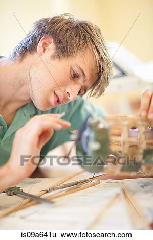 Stock Photograph - Man working on model airplane. Fotosearch