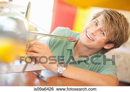 Stock Photograph - Man working on model airplane. Fotosearch