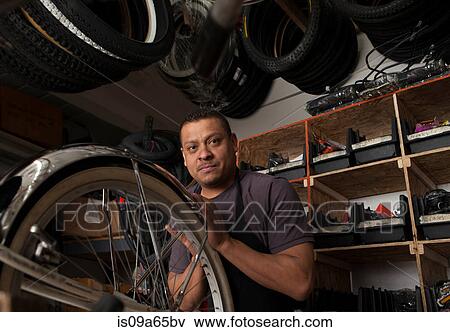 Stock Photo - Mechanic working in bicycle shop. Fotosearch