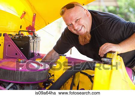 Stock Image - Mechanic working on colorful car. Fotosearch