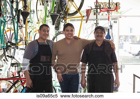 Stock Photography - Mechanics smiling in bicycle shop. Fotosearch