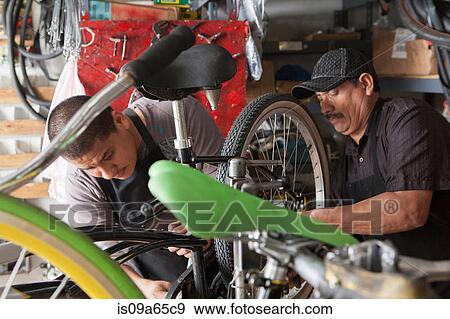 Mechanics working in bicycle shop View Large Photo Image Stock Photo - Mechanics working in bicycle shop. Fotosearch