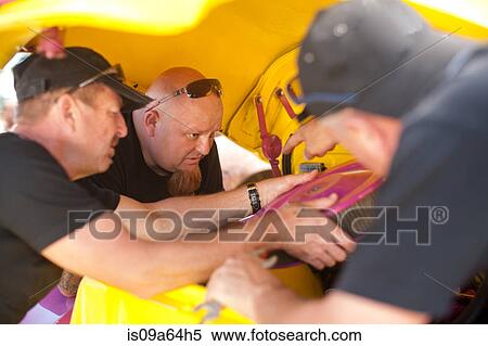Stock Photography - Mechanics working on colorful car. Fotosearch