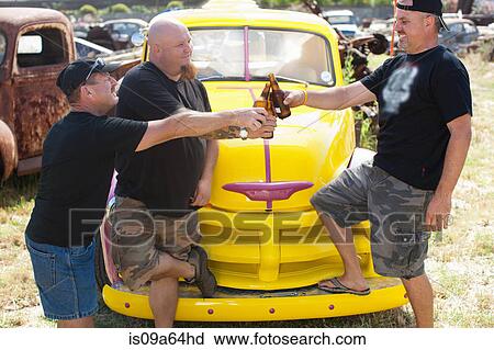 Men drinking beer by colorful car View Large Photo Image Stock Image - Men drinking beer by colorful car. Fotosearch