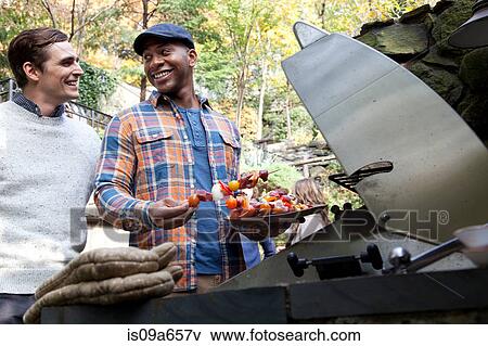Stock Photo - Men grilling kebabs outdoors. Fotosearch