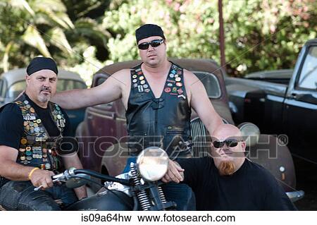 Stock Photo - Men sitting around motorcycle. Fotosearch