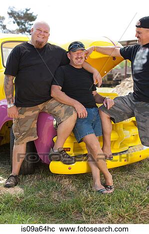 Stock Image - Men smiling with colorful car. Fotosearch