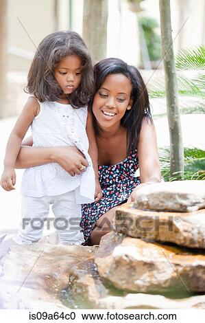 Stock Image - Mother and daughter admiring fountain. Fotosearch