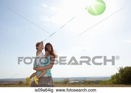 Mother and daughter carrying balloon View Large Photo Image Stock Image - Mother and daughter carrying balloon. Fotosearch