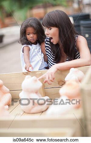 Mother and daughter examining sculpture View Large Photo Image Stock Image - Mother and daughter examining sculpture. Fotosearch