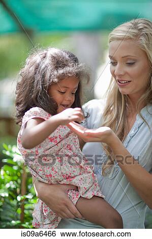 Stock Photograph - Mother holding daughter outdoors. Fotosearch