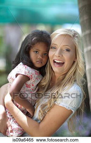 Stock Photography - Mother holding daughter outdoors. Fotosearch
