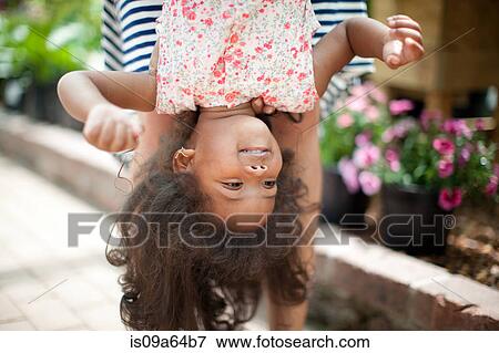 Mother holding daughter upside down View Large Photo Image Stock Photo - Mother holding daughter upside down. Fotosearch