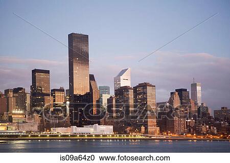 Stock Image - New York City skyline lit up at dusk. Fotosearch