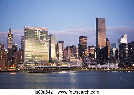 Stock Image - New York City skyline lit up at dusk. Fotosearch