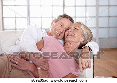 Stock Photography - Older couple relaxing on sofa. Fotosearch