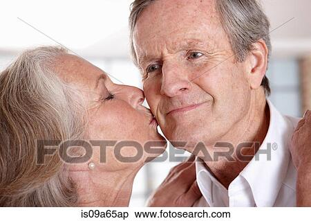 Stock Photography - Older woman kissing husband. Fotosearch