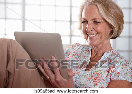 Older woman using tablet computer View Large Photo Image Stock Image - Older woman using tablet computer. Fotosearch