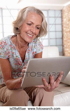 Older woman using tablet computer View Large Photo Image Stock Image - Older woman using tablet computer. Fotosearch