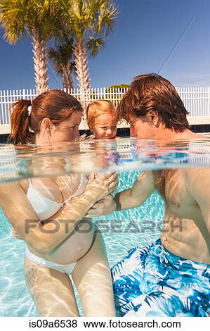 Stock Photo - Parents and toddler in swimming pool. Fotosearch