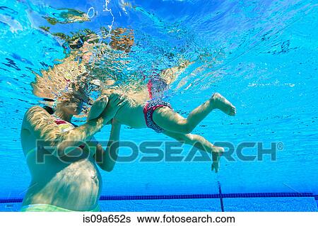 Stock Photograph - Pregnant mother with toddler in pool. Fotosearch