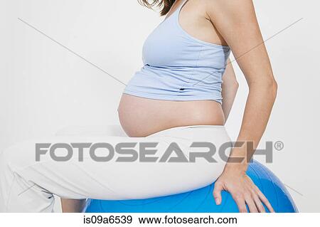 Pregnant woman on exercise ball View Large Photo Image Stock Photo - Pregnant woman on exercise ball. Fotosearch