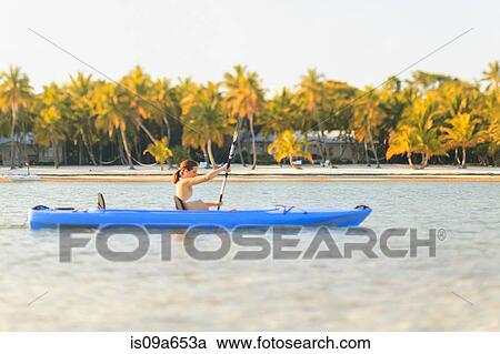 Stock Image - Pregnant woman rowing canoe. Fotosearch
