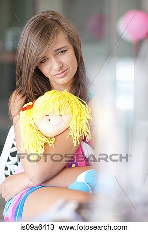Sad teenage girl hugging doll View Large Photo Image Stock Image - Sad teenage girl hugging doll. Fotosearch