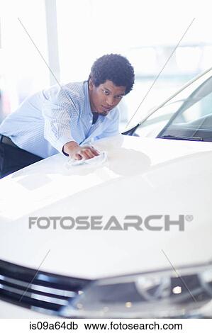 Stock Image - Salesman shining up new car. Fotosearch