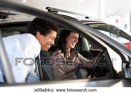 Stock Photo - Salesman showing woman new car. Fotosearch