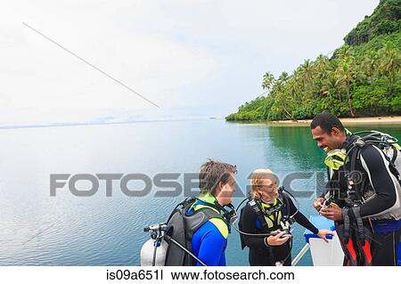 Stock Image - Scuba divers talking on boat. Fotosearch
