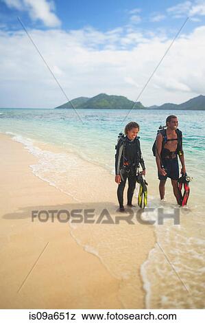 Scuba divers walking on tropical beach View Large Photo Image Stock Photo - Scuba divers walking on tropical beach. Fotosearch