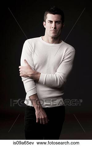Stock Photo - Serious man holding his arm. Fotosearch