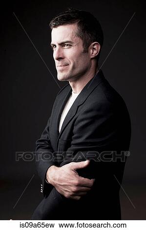 Stock Photo - Serious man holding his arm. Fotosearch