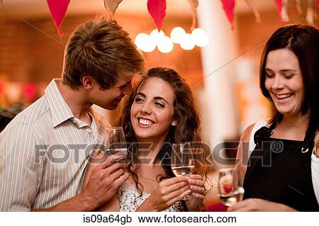 Stock Image - Server and customers tasting wine. Fotosearch
