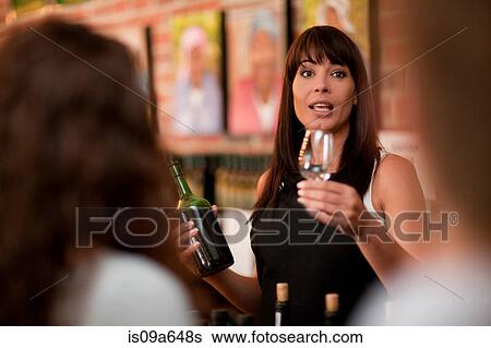 Stock Photograph - Server pouring glass of wine for tasting. Fotosearch