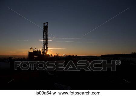 Silhouette of oil well in dry landscape View Large Photo Image Stock Photo - Silhouette of oil well in dry landscape. Fotosearch