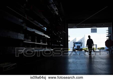 Stock Image - Silhouette of worker in metal plant. Fotosearch