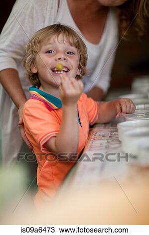 Smiling boy displaying olive in grocery View Large Photo Image Stock Image - Smiling boy displaying olive in grocery. Fotosearch