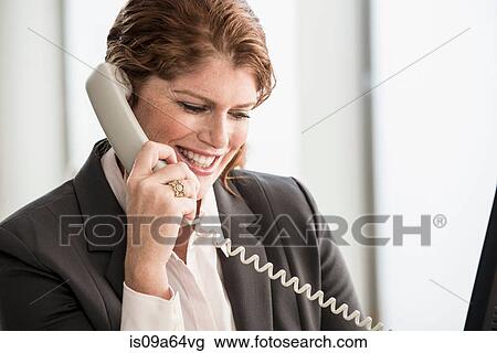 Stock Image - Smiling businesswoman talking on phone. Fotosearch